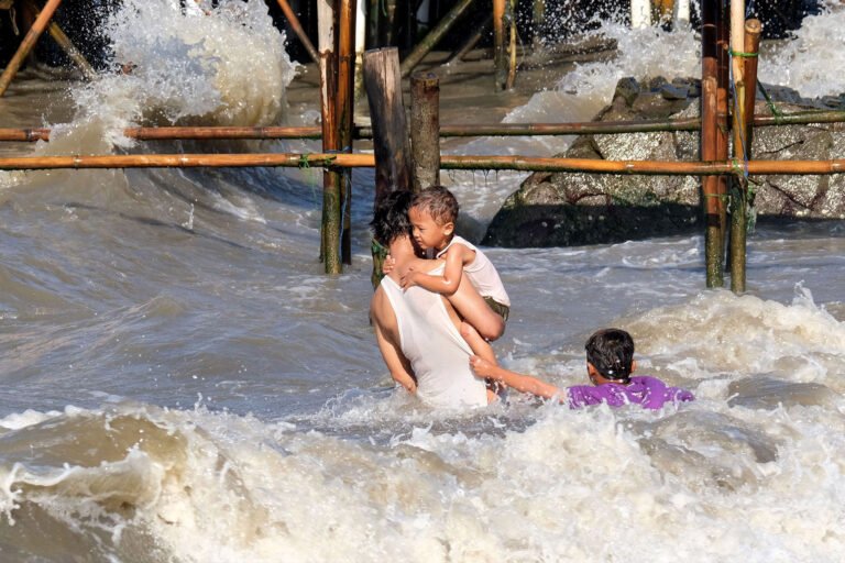 Man trying to rescue two children out of the raging water